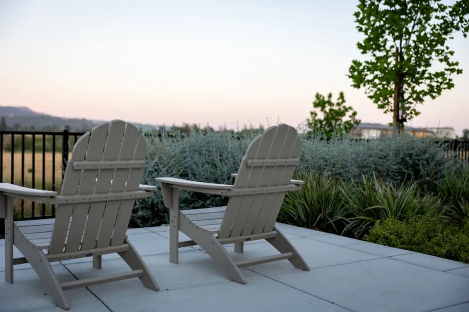 Two chairs on a concrete patio at dusk