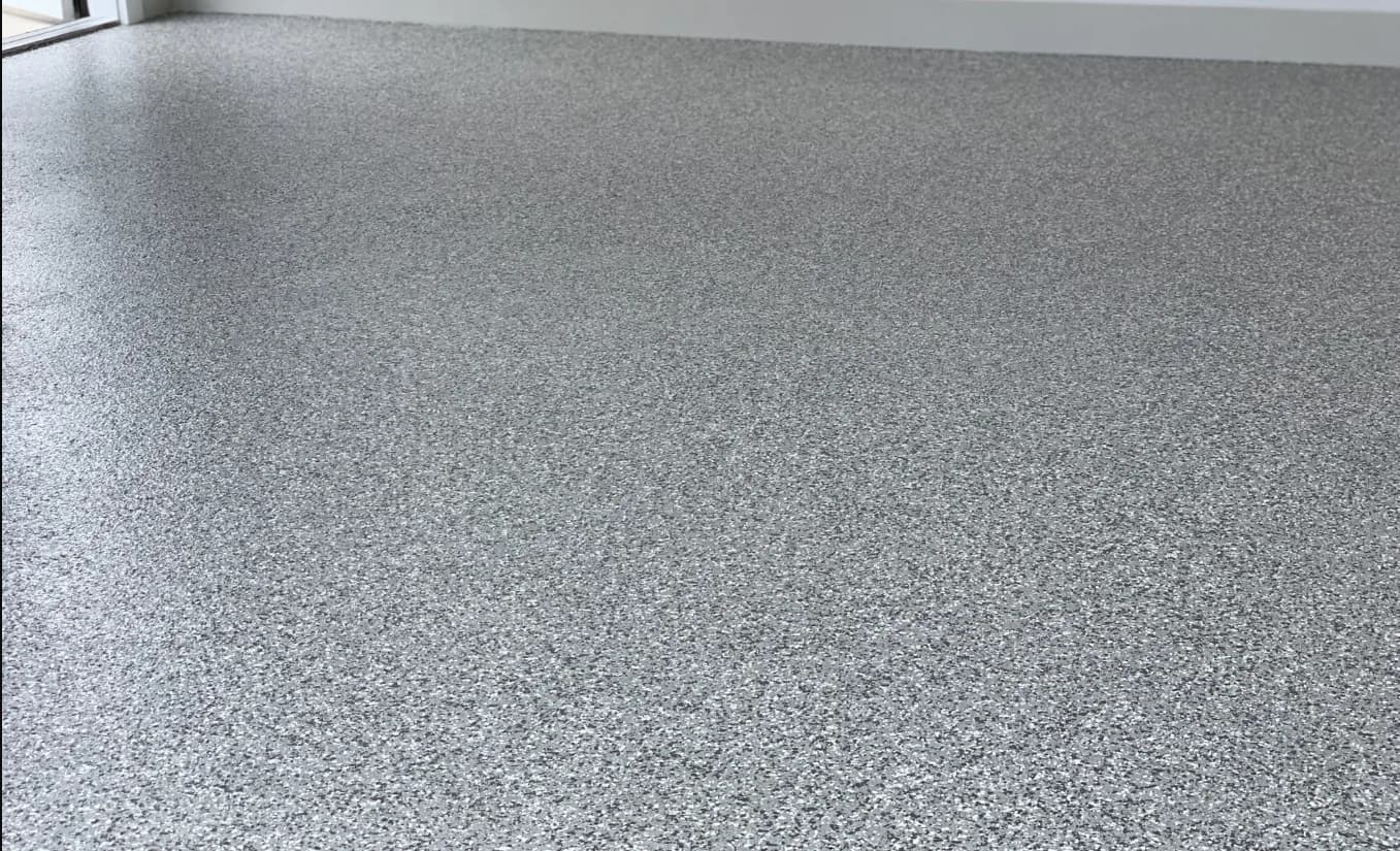 A finished flake floor in daylight through the open garage door