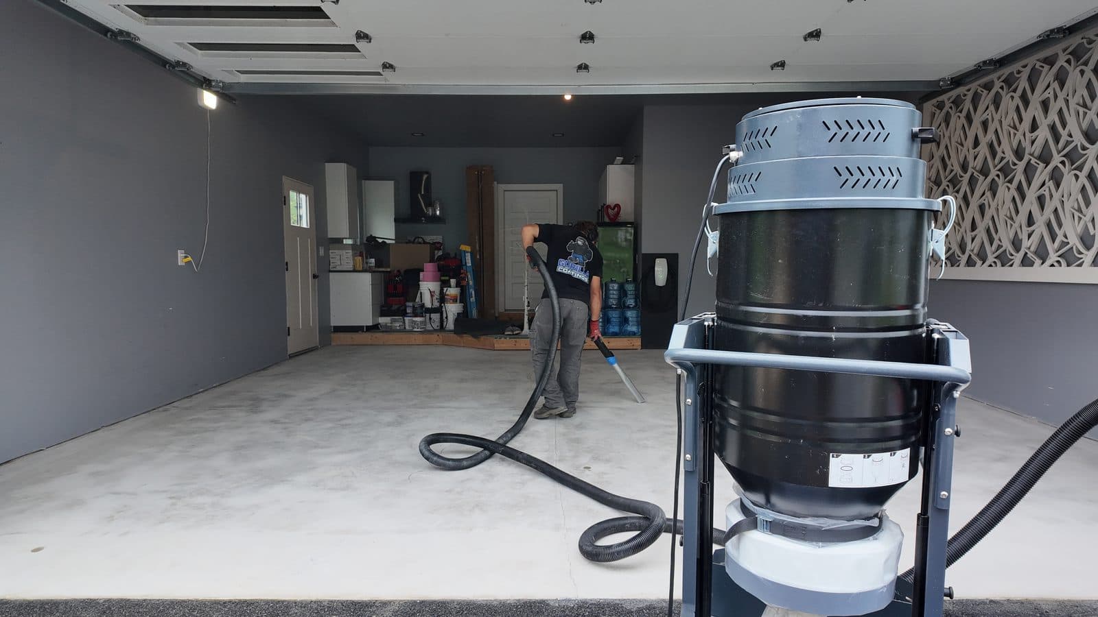 Dust extraction unit running while a crew member grinds the slab